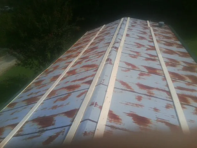 Rusted metal roof panels with new wood purlins before replacement — Storm Damage Roof Repair in Hendrix by Roofing Brothers